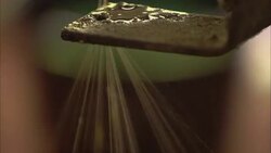 A machine pulls silk threads from a kettle of boiling silk cocoons. Stock Footage