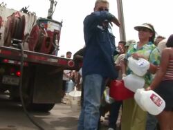 MS TU TD Shot of man filling gas can from truck as people waiting in line for fuel as Hurricane Rita approaching Texas / Texas, United States Stock Footage