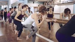 Young women doing exercise next to mirror Stock Footage