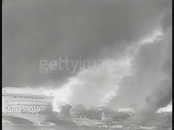 1941: JAPANESE FORCES IN PHILIPPINES: MANILA: Tanks moving on road w/ house BG. Manila cityscape, smoking. Hanging banner 'Open City' over Manila street. Japanese tanks moving into city. Invasion, Occupation, WWII, World War II. Instructional Video