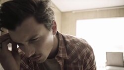 Young man seethes on motel bed as young woman paces back and forth behind him Stock Footage