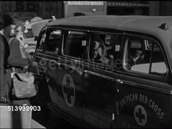 1946: RETURNING HOME: NEW YORK CITY: ANGLED WS Pennsylvania Station (aka Penn Station) in Manhattan. VS Group of females carrying luggage, getting into 'Red Cross' vehicle. INT VS Females in car, looking out at city street, pedestrians. NYC Instructional Video