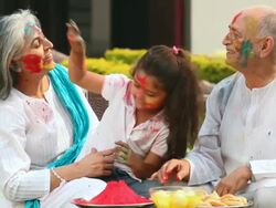 Girl celebrating holi festival with her grandparents Stock Footage