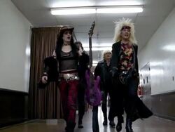 Slow motion low angle medium shot tracking shot glam band walking in hallway backstage / raising their instruments Stock Footage