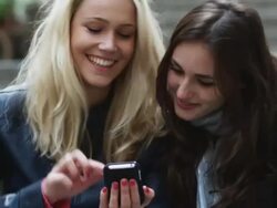 two women on a city street looking at an phone Stock Footage