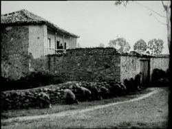 Soldiers run through a village, shooting guns and cannons during the Spanish Civil War. News Clip
