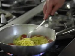 Close up shot of a chef cooking tomato and basil spaghetti into pan Stock Footage