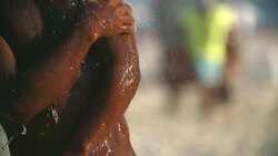 Brazilian athlete showers on beach after intense footvolley match Stock Footage