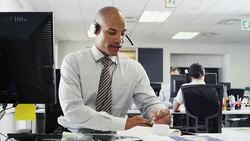 Businessman wearing headset using computer Stock Footage