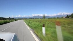 POV from car driving along a countryside road with mountains in the distance Stock Footage