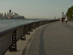 A group of joggers running down the waterfront sidewalk in Hoboken NJ Stock Footage