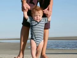 MS Shot of mother and baby walking on beach / St Simon's Island, Georgia, United States Stock Footage