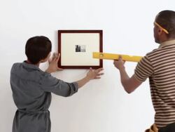 Couple putting up picture Stock Footage