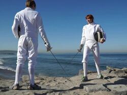 A man and woman fencing on the beach. - Slow Motion Stock Footage
