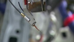 A tube hangs below a machine at an automobile factory in Chattanooga, Tennessee. Stock Footage