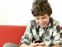 Kid playing games or texting on mobile phone Stock Footage