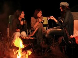 Three young women enjoying campfire in the forest, Delhi, India Stock Footage