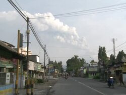 Merapi volcano erupts at dawn visible from northern suburb of Yogjakarta city; Indonesia. 7 November 2010 / AUDIO Stock Footage