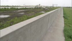 A  New Orleans levee divides a distant canal from a grassy zone on the opposite side. Stock Footage