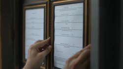 Restaurant owner hangs menu on exterior wall Stock Footage
