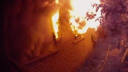 Slow Motion firefighter POV smashing window of burning home with axe Stock Footage