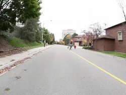  WS PAN Residential street in with man riding  bike and wearing halloween pumpkin mask with kids on bike  / Toronto, Ontario, Canada Stock Footage