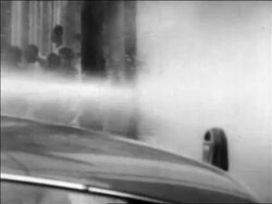 B/W 1963 man hiding behind pole as demonstrators get hosed in civil rights riot / Alabama / newsreel Stock Footage
