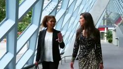 MS TS Two businesswomen in discussion while walking outside of office building Stock Footage