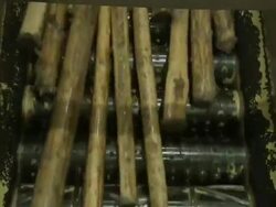 Medium Close Up hand-held static - Logs move across toothed rollers in a paper mill / Borlange, Sweden Stock Footage