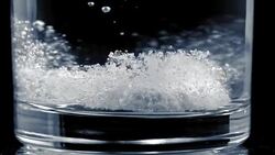 SLO MO Fizzing tablet landing on bottom of a glass Stock Footage