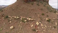 Rocks and scrub brush cover a conical hillside. Stock Footage