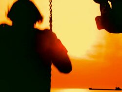 boy and woman on a swing at sunset Stock Footage