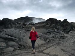 WS Steam pouring out of volcanic black landscape, young woman walking up on volcanic rock at leirhnjukur / Krafla, Myvatn region, Iceland Stock Footage