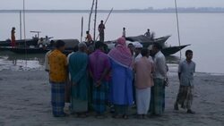 Fisherman return to the banks of the River Jamuna Bangladesh at sunset to unload sell auction and share their catch of small fish before tending to nets and returning home Stock Footage