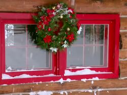 MS Christmas wreath on log home window during winter / Tweed, Ontario, Canada Stock Footage