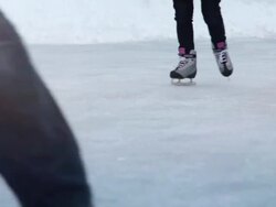 People skating toward the camera, through a sun flare (Loopable) Stock Footage