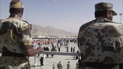 Military personnel overlook a pilgrimage into Mecca. Stock Footage