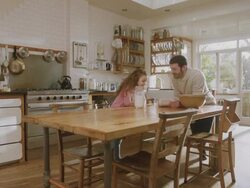 MS Shot of Daddy & daughter in kitchen discuss recipe, girl jumping with excitement / London, United Kingdom  Stock Footage