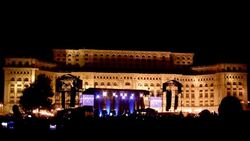Silhouetted members of a crowd cheer during an evening concert at the Palace of the Parliament in Bucharest, Romania. Stock Footage
