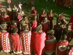 High Angle - Maasai men dance as others sing, dance, and play musical instruments in Africa / Kenya Stock Footage