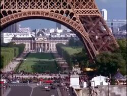 MS Traffic passing underneath base of Eiffel tower, leading to Military Academy, Paris Stock Footage