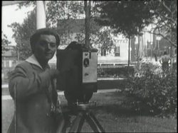 A man turns a lever on a film camera. News Clip