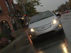 WS POV Electric car being driven in city traffic in rain / Rochester, Michigan, United States Stock Footage