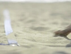ECU of female beach volleyball players feet and legs as she serves. Stock Footage
