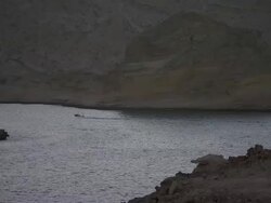 MS small motor boat crossing between two sandstone colored cliffs / Muscat, Oman Stock Footage