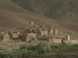 Heat flickers off the landscape of a small collection of Moroccan buildings.  Stock Footage