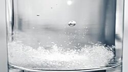 SLO MO Tablet landing in the glass creating bubbles Stock Footage