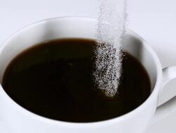 CU SLO MO Sugar being poured into bowl of coffee / Vieux Pont, Normandy, France Stock Footage