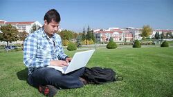 Student Using Laptop On Grass Stock Footage