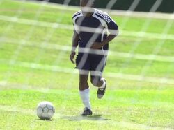 A man playing soccer on a grassy field. - Slow Motion - filmed at 240 fps Stock Footage